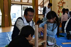 町建設組合員から指導を受け、いす作りに挑戦する園児