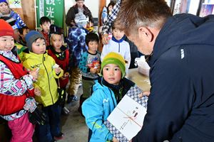 抽選会で当選した参加者に商品が手渡される様子